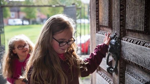 Two girls enter Mompesson House through the front door.